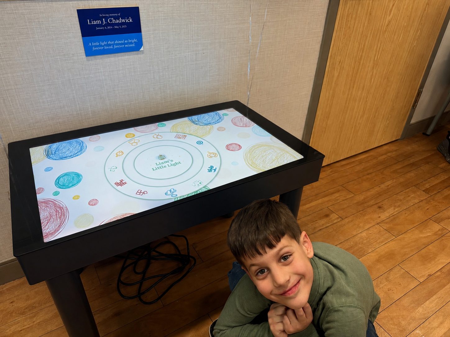 Liam's family at the interactive table in the Butterfly Room